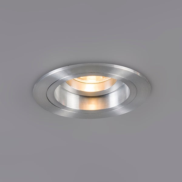 Runder Einbaustrahler aus gebürstetem Metall mit schwenkbarem warmweißem Leuchtmittel.