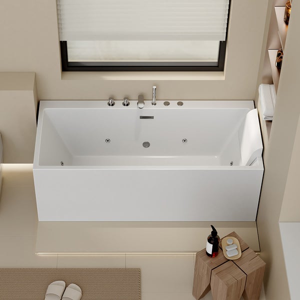 Rechteckige Whirlpool-Badewanne in Weiß mit Armaturen und Kopfstütze in einem hellen, modernen Badezimmer unter einem Fenster.