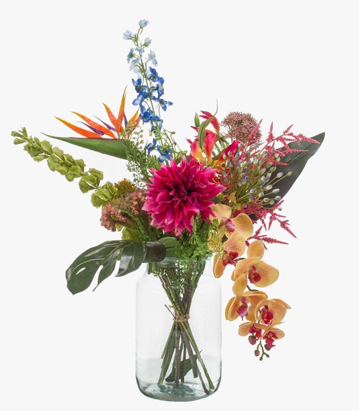 Künstlicher Blumenstrauß mit rosa Dahlie, grünen Blättern und Monstera-Blatt in einer transparenten Glasvase.