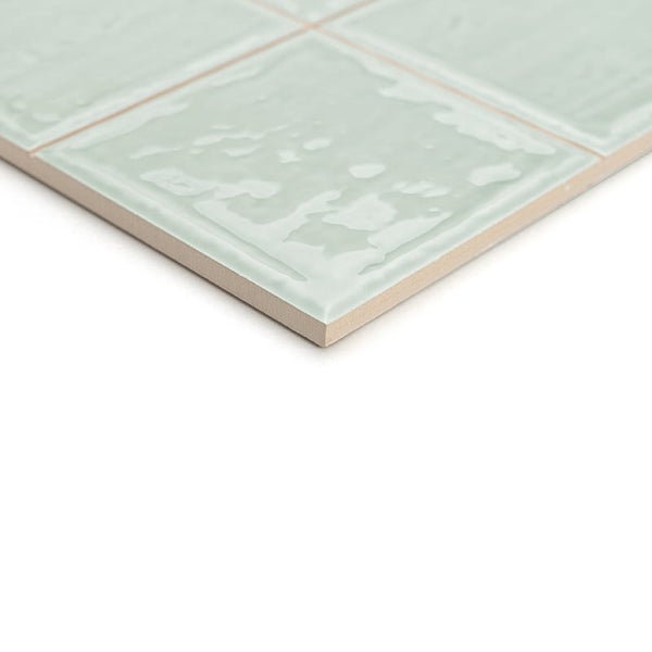 Wandfliese mit strukturierter Oberfläche und glänzender Glasur im quadratischen Format in der Nahaufnahme.