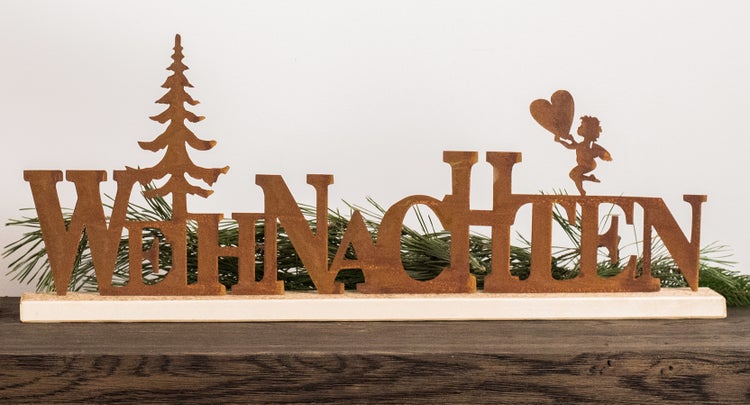 Weihnachtsschriftzug aus Metall mit Edelrostoptik, Tannenbaum und Engel mit Herz auf einem Holzsockel zur Dekoration.