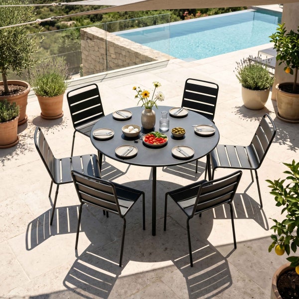 Modernes Gartenmöbel-Set bestehend aus einem runden Tisch und sechs schwarzen Stühlen aus Metall auf einer hellen Steinterrasse neben einem Pool.