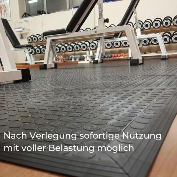 Gummiboden im Fitnessstudio mit Hantelbank und Gewichten