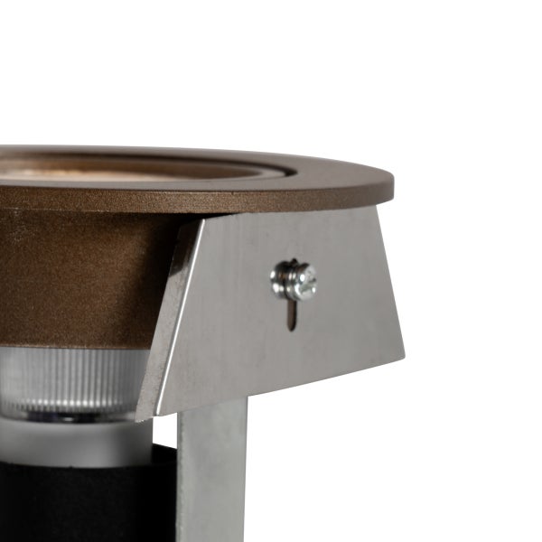 Detailansicht eines braunen Bodeneinbaustrahlers mit silbernem Metallbügel und Schraube.