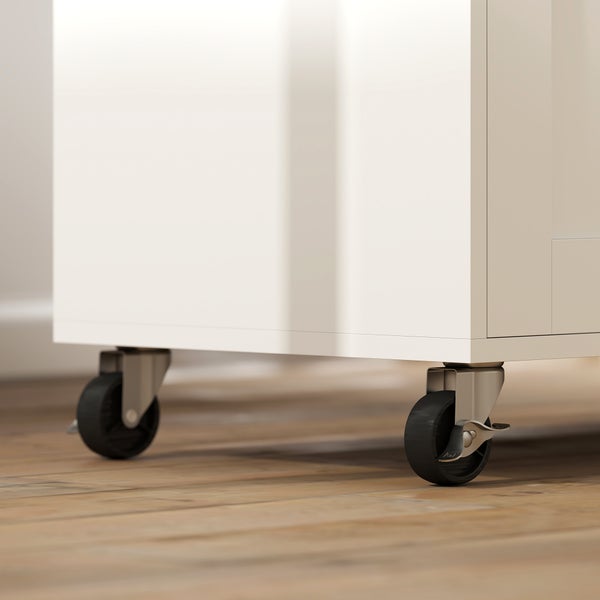 Möbelrollen aus Metall und Kunststoff an einem weißen Schrank auf Holzboden.