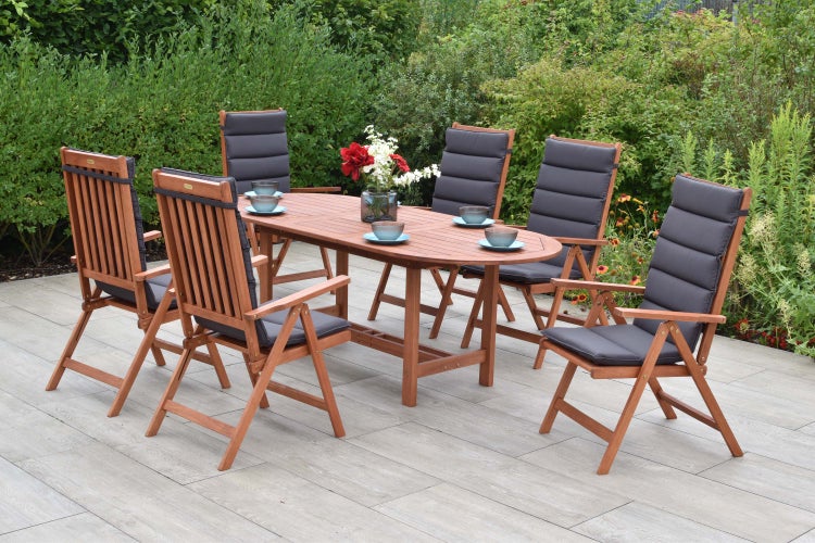 Gartensitzgruppe mit ovalem Tisch und sechs Stühlen mit Polsterauflagen im Garten