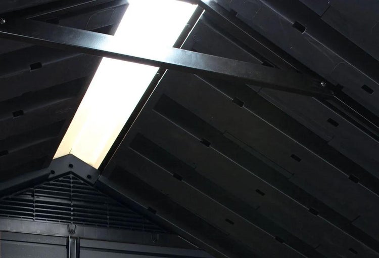 Innenansicht eines Gerätehausdachs mit einem lichtdurchlässigen Oberlicht und dunklen Metallstützbalken.