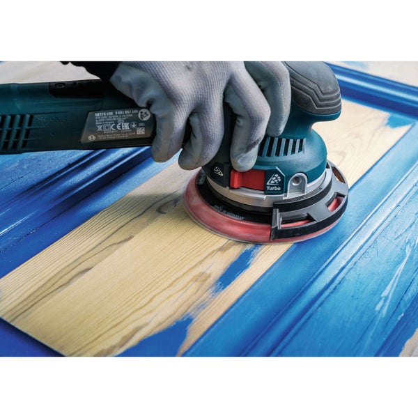 Ein Schwingschleifer mit Schleifpapier bearbeitet ein Stück Holz.