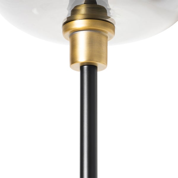 Detailaufnahme einer Leuchte mit Lampenschirm, goldfarbener Fassung und schwarzem Stab