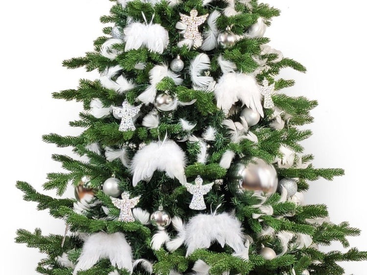 Weihnachtsbaum geschmückt mit silbernen Kugeln, glitzernden Engelanhängern und Federflügeln.