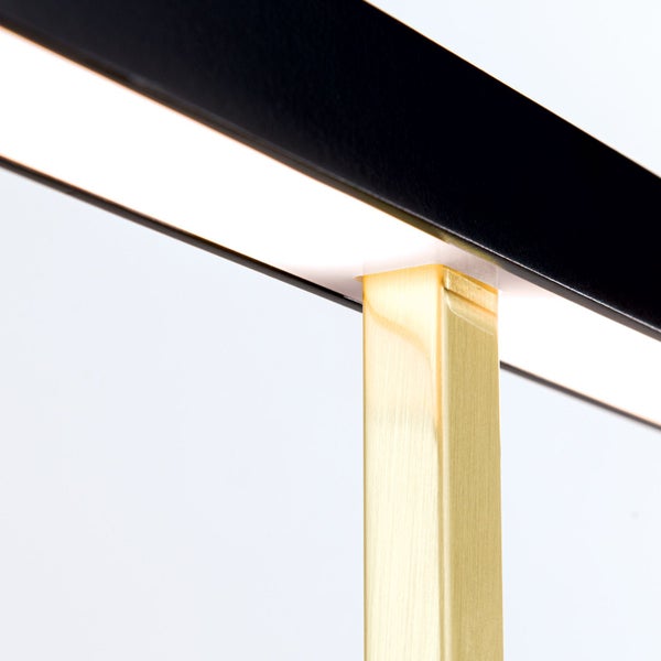 Detailaufnahme einer modernen Lampe mit schwarzen und messingfarbenen Elementen