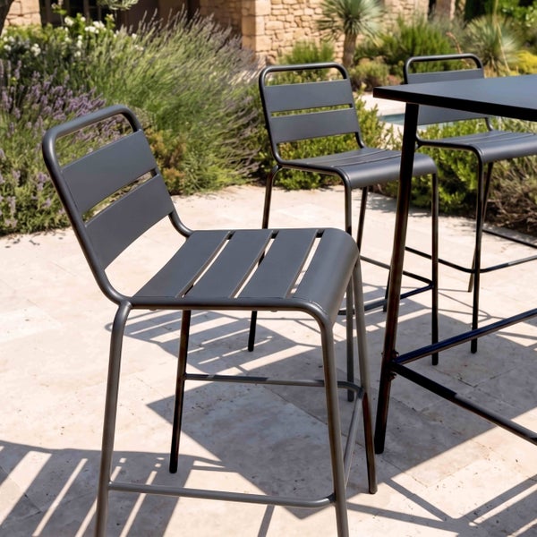 Moderne Gartenbarhocker aus Metall mit Sitzfläche und Rückenlehne aus Latten auf einer Terrasse mit passendem Stehtisch.