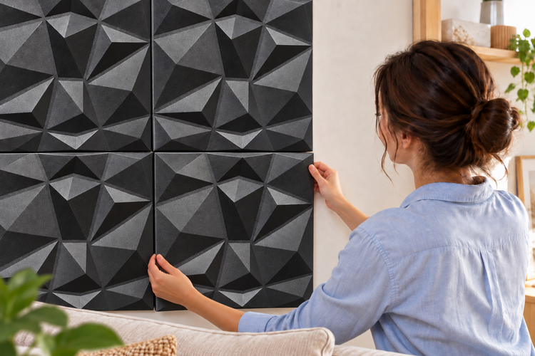 Frau montiert quadratische Wandpaneele mit geometrischer 3D Struktur an einer Innenwand im Wohnbereich.