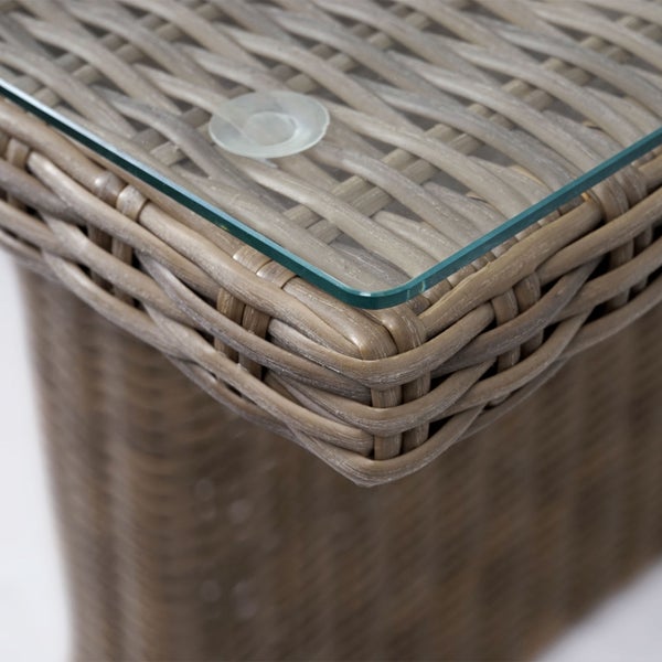 Detailaufnahme einer Gartentisch-Ecke aus Polyrattan-Geflecht mit einer Glasplatte auf Saugnäpfen.