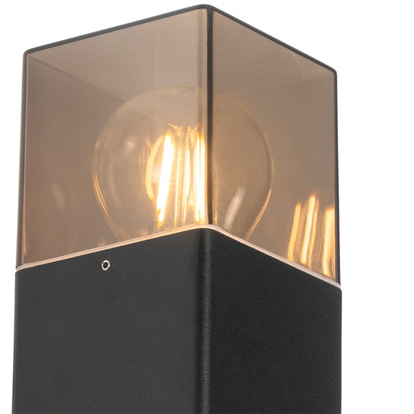 Moderne Außenleuchte mit schwarzem, quadratischem Sockel und einem würfelförmigen Schirm aus Rauchglas, inklusive sichtbarem Filamentleuchtmittel.