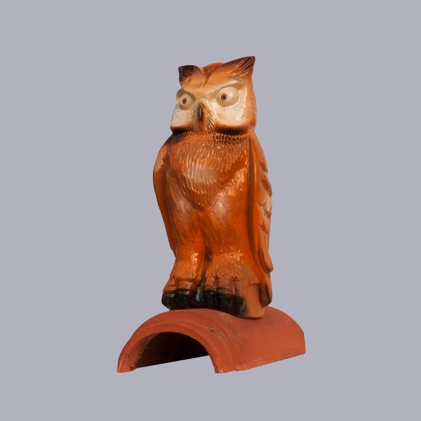 Firstfigur Eule aus Keramik auf einem Firstziegel zur Dachdekoration.