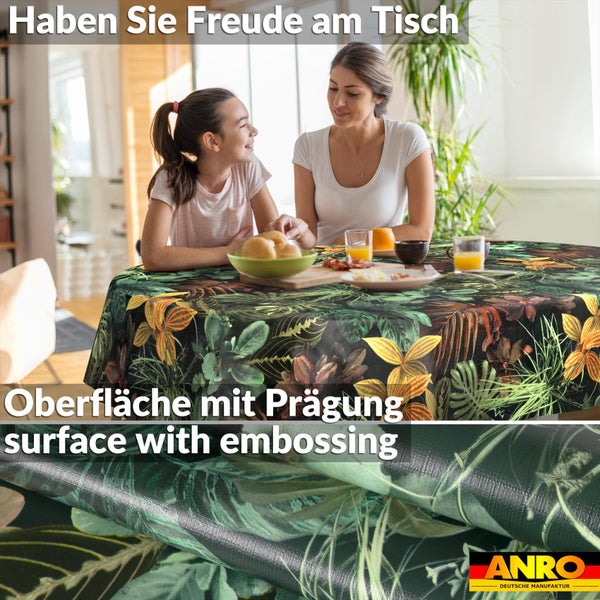 Runde Tischdecke mit tropischem Blättermuster und geprägter Oberfläche an einem hellen Esstisch mit Mutter und Kind. ANRO Logo.