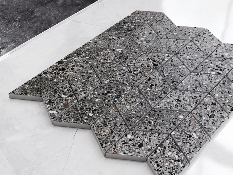 Mosaikfliese aus Feinsteinzeug in Terrazzo-Optik, rautenförmig angeordnet, für Wand und Boden geeignet.