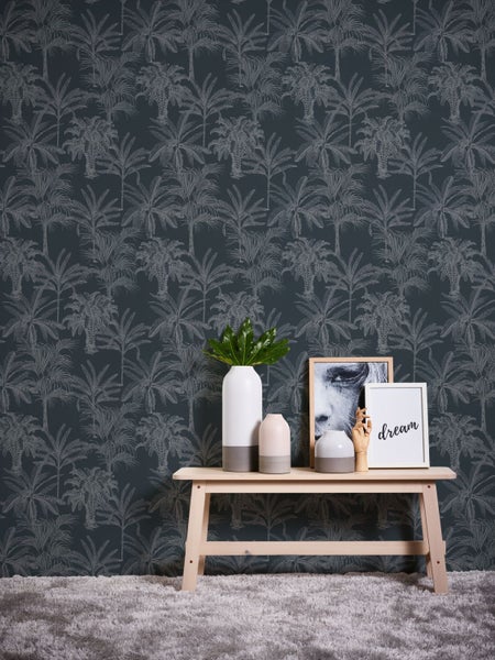 Dekoratives Zimmer mit gemusterter Tapete und Holzhocker