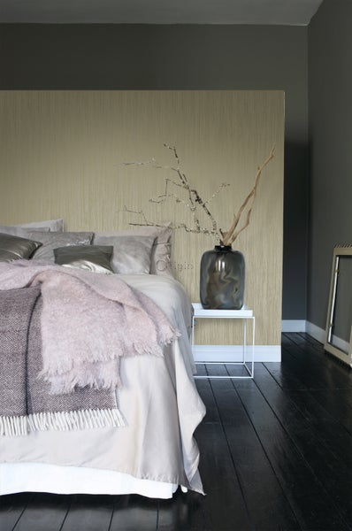 Schlafzimmer mit Bett, Nachttisch und strukturierter Tapete