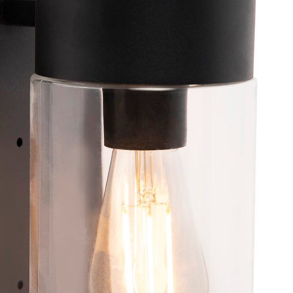 Schwarze Außenwandleuchte mit klarem Glaszylinder und brennendem LED-Filament-Leuchtmittel.