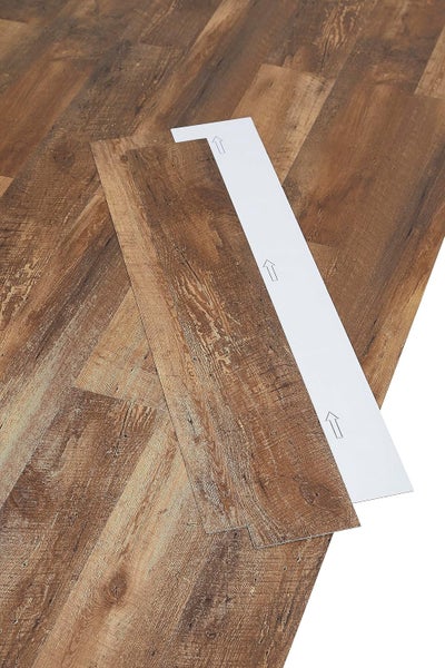 Selbstklebende Vinyl-Laminatdiele in Holzoptik mit abziehbarer Schutzfolie und Verlegepfeilen.