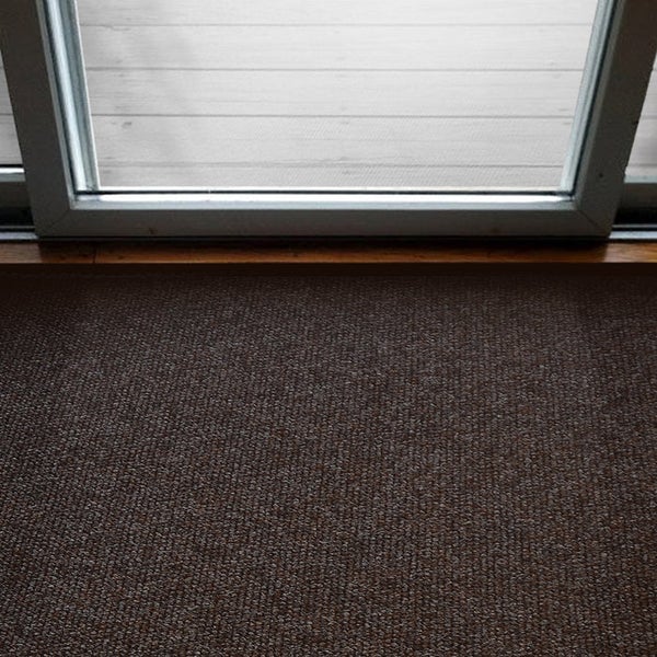 Detailansicht eines braunen Teppichs vor einer Terrassentür