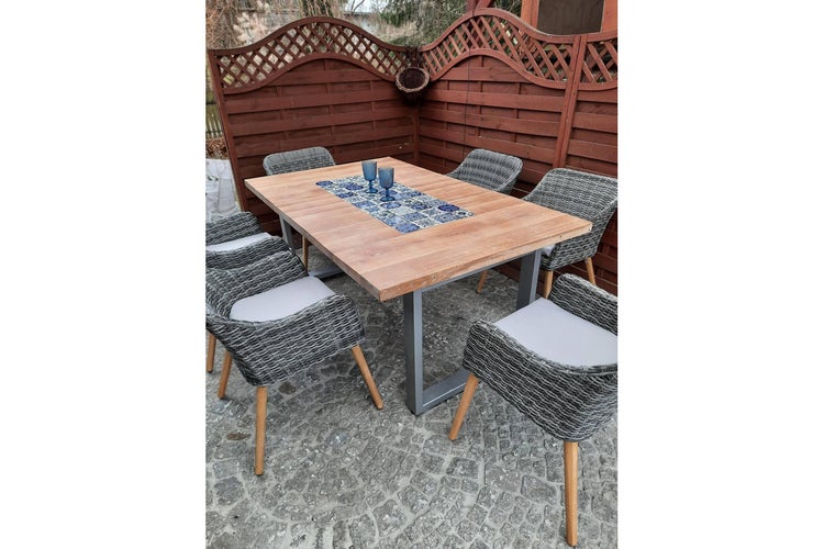 Gartensitzgruppe mit Holztisch und sechs Korbstühlen im Außenbereich