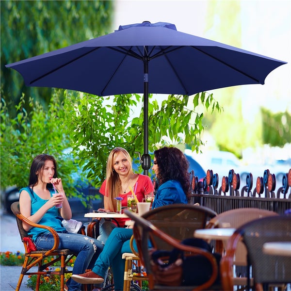 Szene im Freien mit einem Sonnenschirm über einem Tisch mit drei Personen