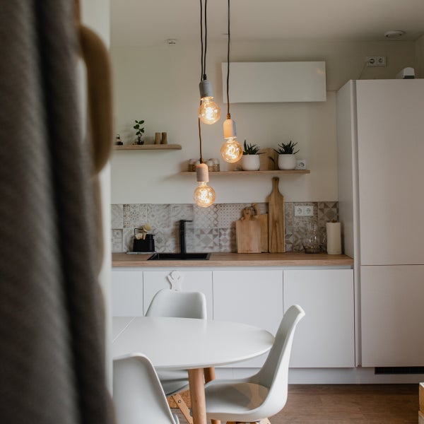 Helle Küche mit Esstisch, Pendelleuchten und Küchenutensilien