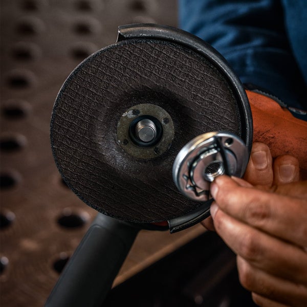 Nahaufnahme eines Winkelschleifers mit Schleifscheibe und Spannmutter