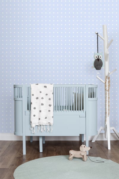 Kinderzimmer mit Babybett, Spielzeug und Wandtapete mit Sternenmuster