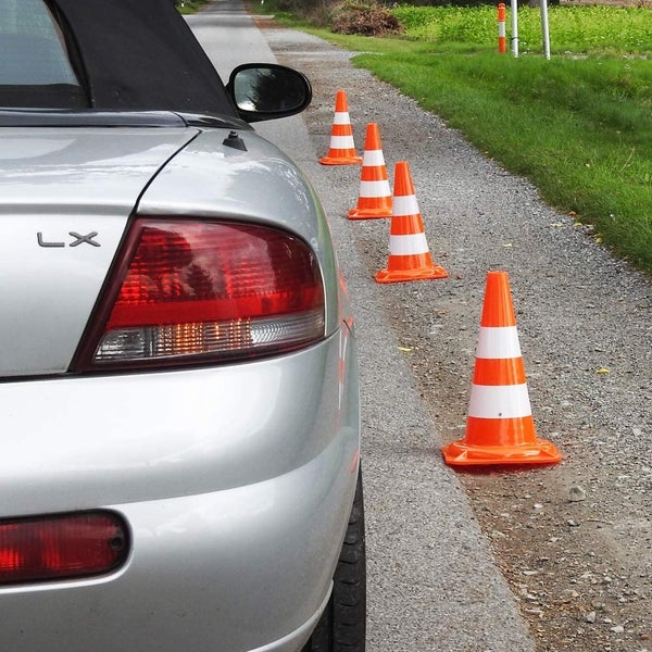 Gartenszene mit großem Sonnenschirm, der mit Lichtern beleuchtet ist, und einer Essgruppe im Freien bei Nacht.