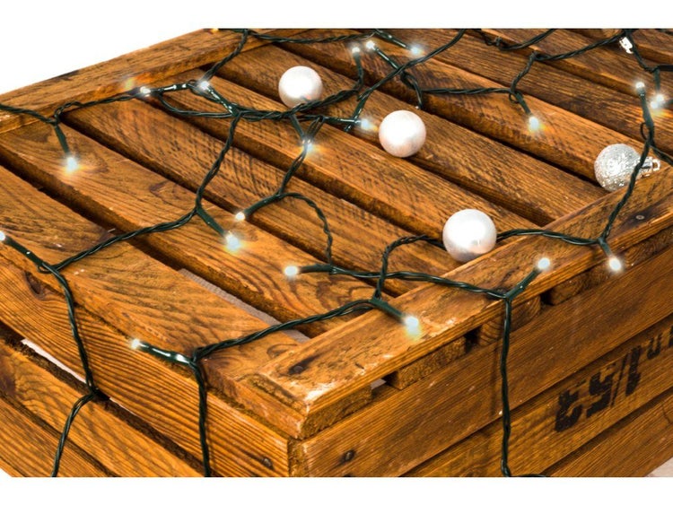 LED Lichterkette fuer den Innenbereich und Aussenbereich mit Dekokugeln auf einer Holzkiste dekoriert