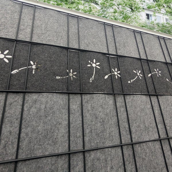 Gartenzaun mit grauem Sichtschutz und Blumenmuster