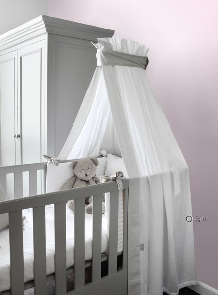 Graues Babybett mit Himmel und Stofftier im Kinderzimmer