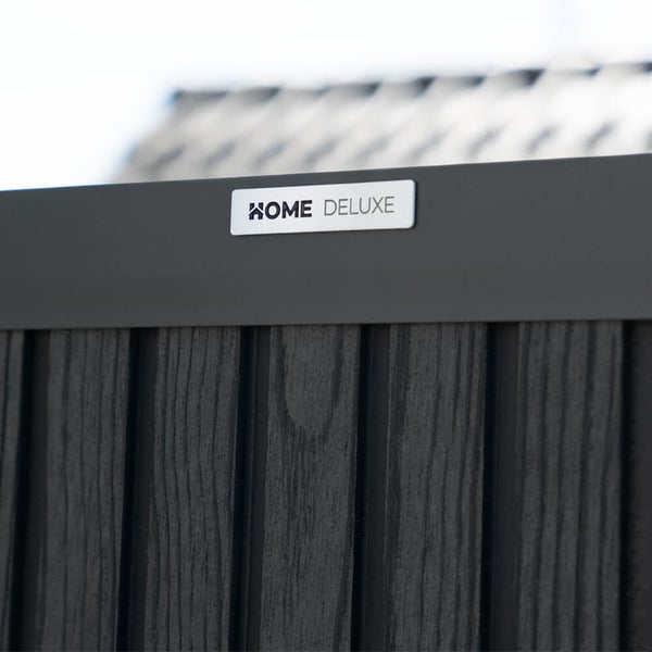 Home Deluxe Logo auf einer strukturierten Zaunoberfläche aus Verbundwerkstoff