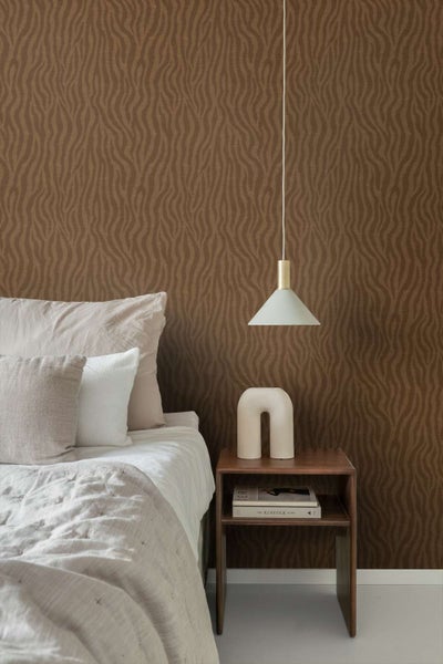 Schlafzimmer mit Vliestapete mit organischem Wellenmuster hinter einem Nachttisch aus Holz und einer Pendelleuchte mit Textilkabel.