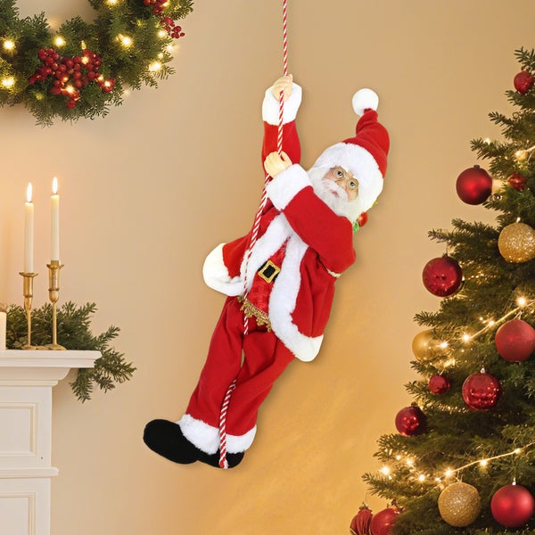 Kletternder Weihnachtsmann an einem Seil, Dekorationsfigur in einem festlich geschmückten Wohnzimmer mit Weihnachtsbaum und Kamin.