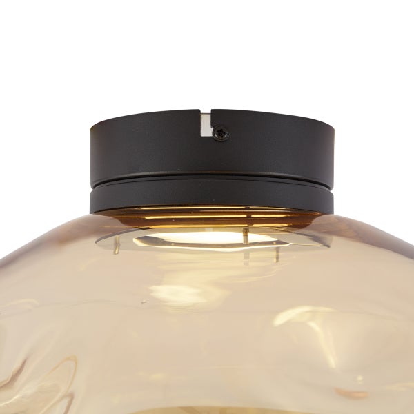 Detailaufnahme einer Deckenleuchte mit Glasschirm und Metallfassung