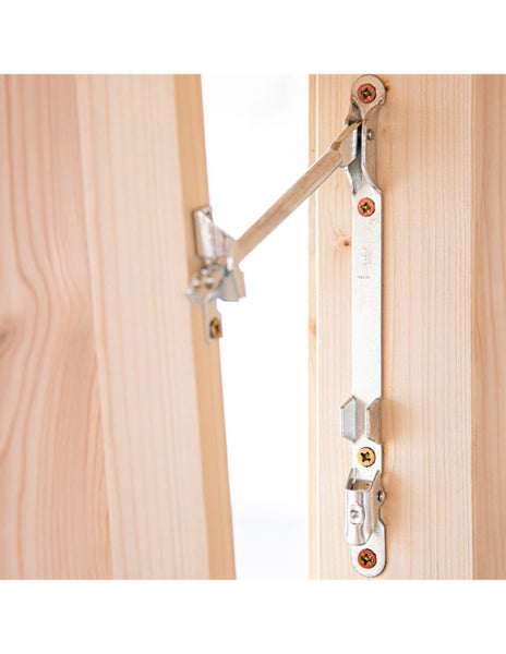 Fensterfeststeller aus Metall an einem Holzfenster montiert zur Arretierung des Fensterflügels.