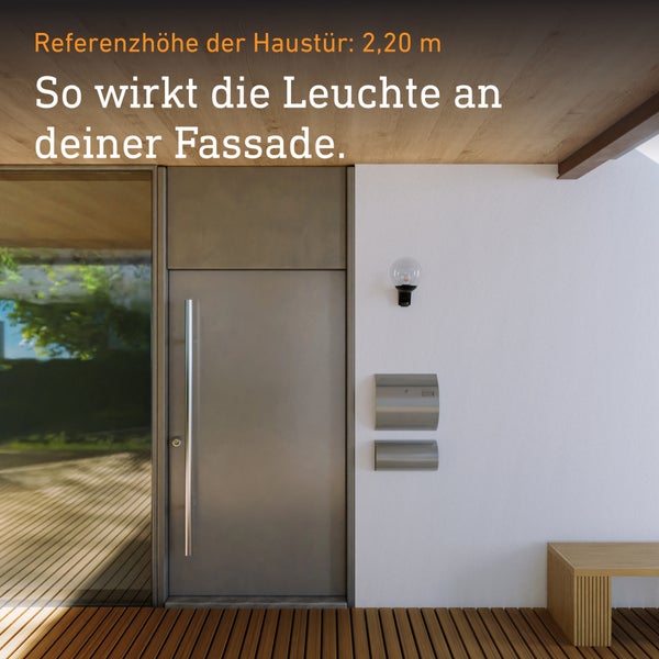 Moderne Außenwandleuchte mit Glaskugel an einer weißen Fassade neben einer Haustür aus Metall.