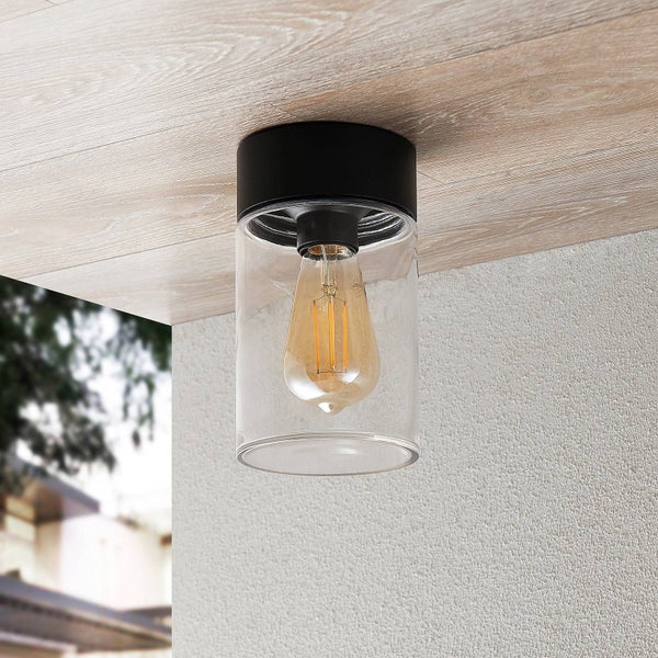 Zylindrische Deckenleuchte mit schwarzer Halterung und klarem Glas, montiert an einer Holzdecke, inklusive LED-Filament-Leuchtmittel.