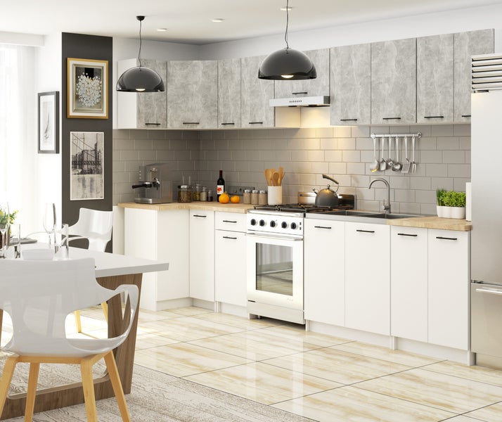 Helle, moderne Küche mit weißen Unterschränken, Arbeitsplatte aus Holz, grau gemusterten Hängeschränken und Essbereich