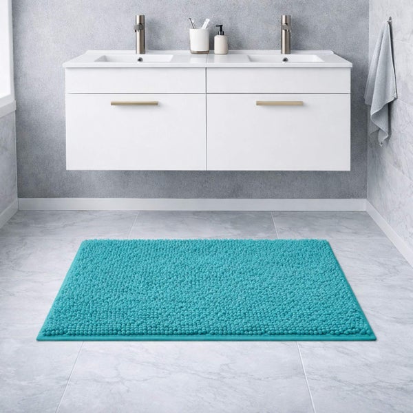 Rechteckige Chenille-Badematte in Türkis vor einem weißen Doppelwaschtisch in einem modernen Badezimmer.