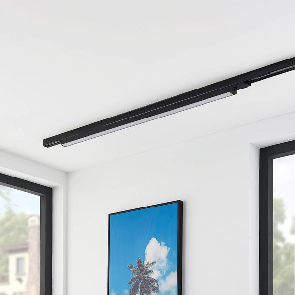 Schwarzes LED-Schienensystem an einer weißen Zimmerdecke montiert, modernes Design über einem Bild an der Wand.