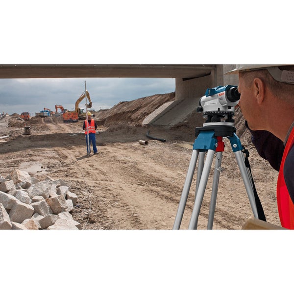 Baustelle mit Nivelliergerät auf Stativ im Einsatz