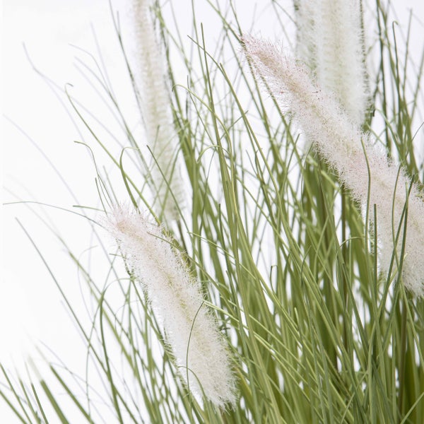 Künstliches Ziergras mit flauschigen weißen Blütenwedeln.