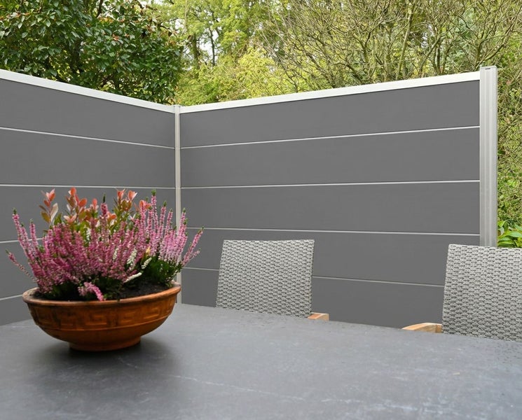 Gartenszene mit Sichtschutzzaun, Tisch, Stühlen und Topfpflanze