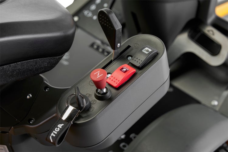 Nahaufnahme der Bedienelemente eines Rasentraktors, inklusive Zündschlüssel, Hebel und Schalter